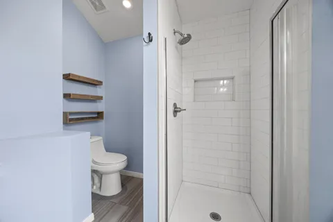 a bathroom view of a toilet and a shower