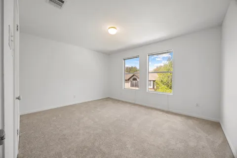 an empty room with windows and door