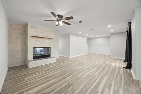 a view of empty room with wooden floor and fireplace