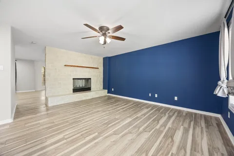 a view of an empty room with a fireplace and a window