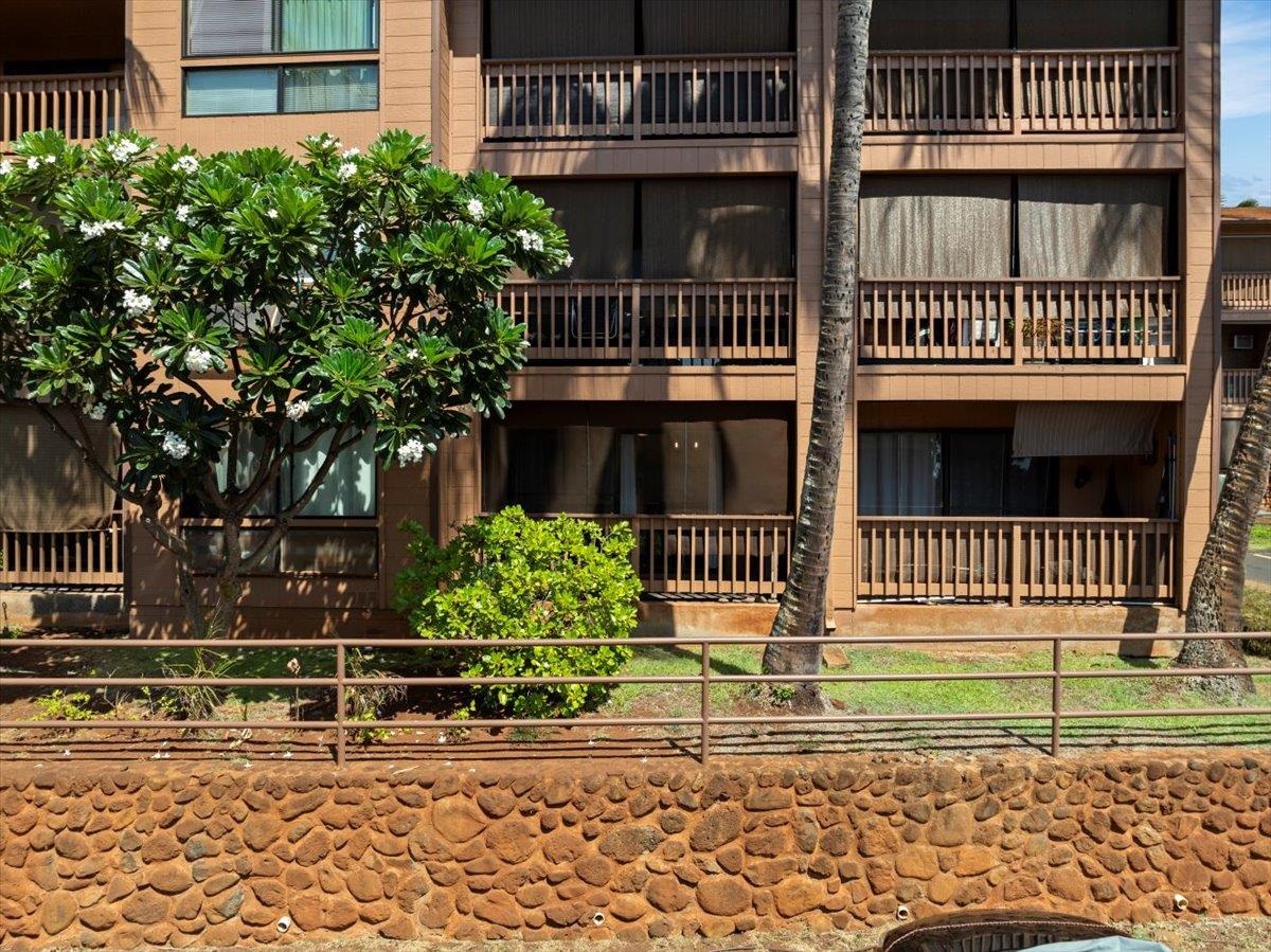 3740 Lower Honoapiilani Road, Unit E102 Lahaina, HI 96761 - Photo 16 of 41 a view of a brick house with many windows and plants