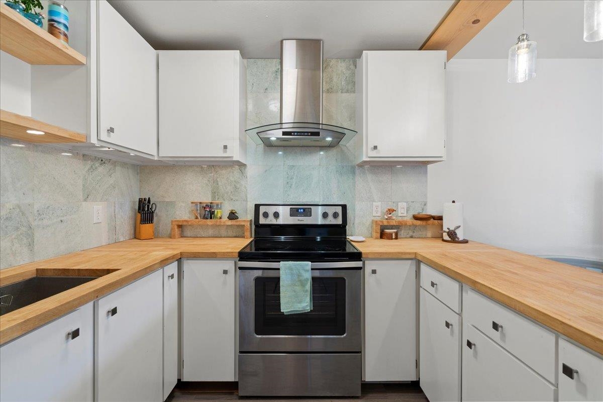 3740 Lower Honoapiilani Road, Unit E102 Lahaina, HI 96761 - Photo 23 of 41 a kitchen with stainless steel appliances white cabinets and a sink