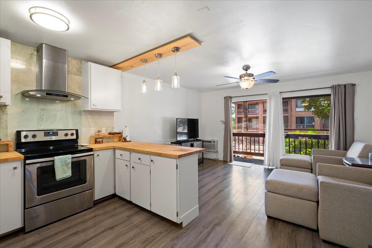 3740 Lower Honoapiilani Road, Unit E102 Lahaina, HI 96761 - Photo 3 of 41 a kitchen with a stove and a wooden floor