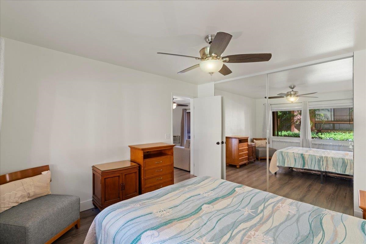 3740 Lower Honoapiilani Road, Unit E102 Lahaina, HI 96761 - Photo 35 of 41 a bedroom with a bed and wooden floor