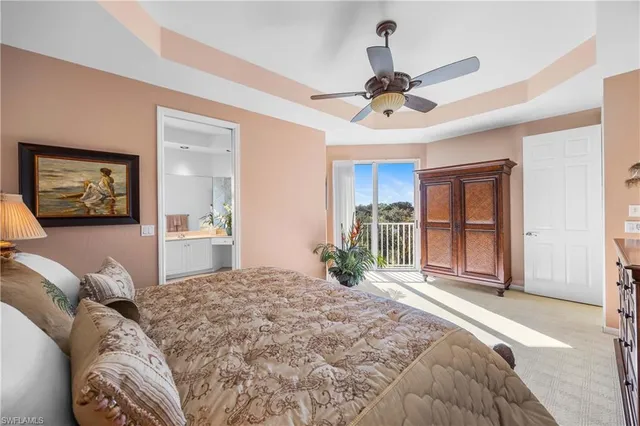 a bedroom with a large bed and a chandelier fan