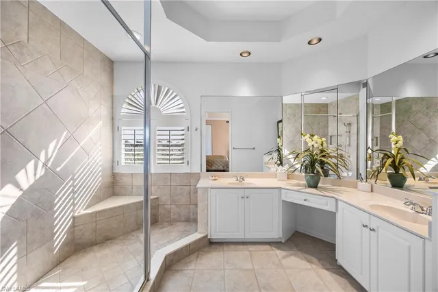 a spacious bathroom with a sink a mirror a bathtub and next to a window