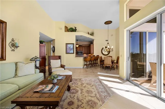 a living room with furniture kitchen view and a large window