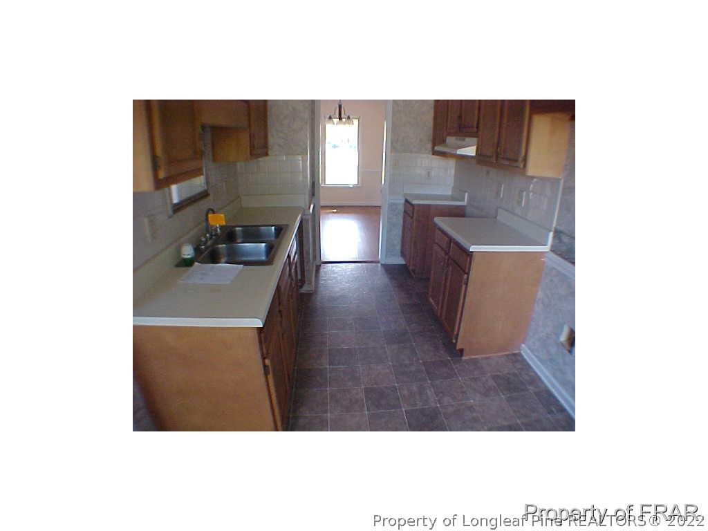 4546 Legion Road Hope Mills, NC 28348 - Photo 5 of 11 a kitchen with granite countertop a sink and a stove top oven