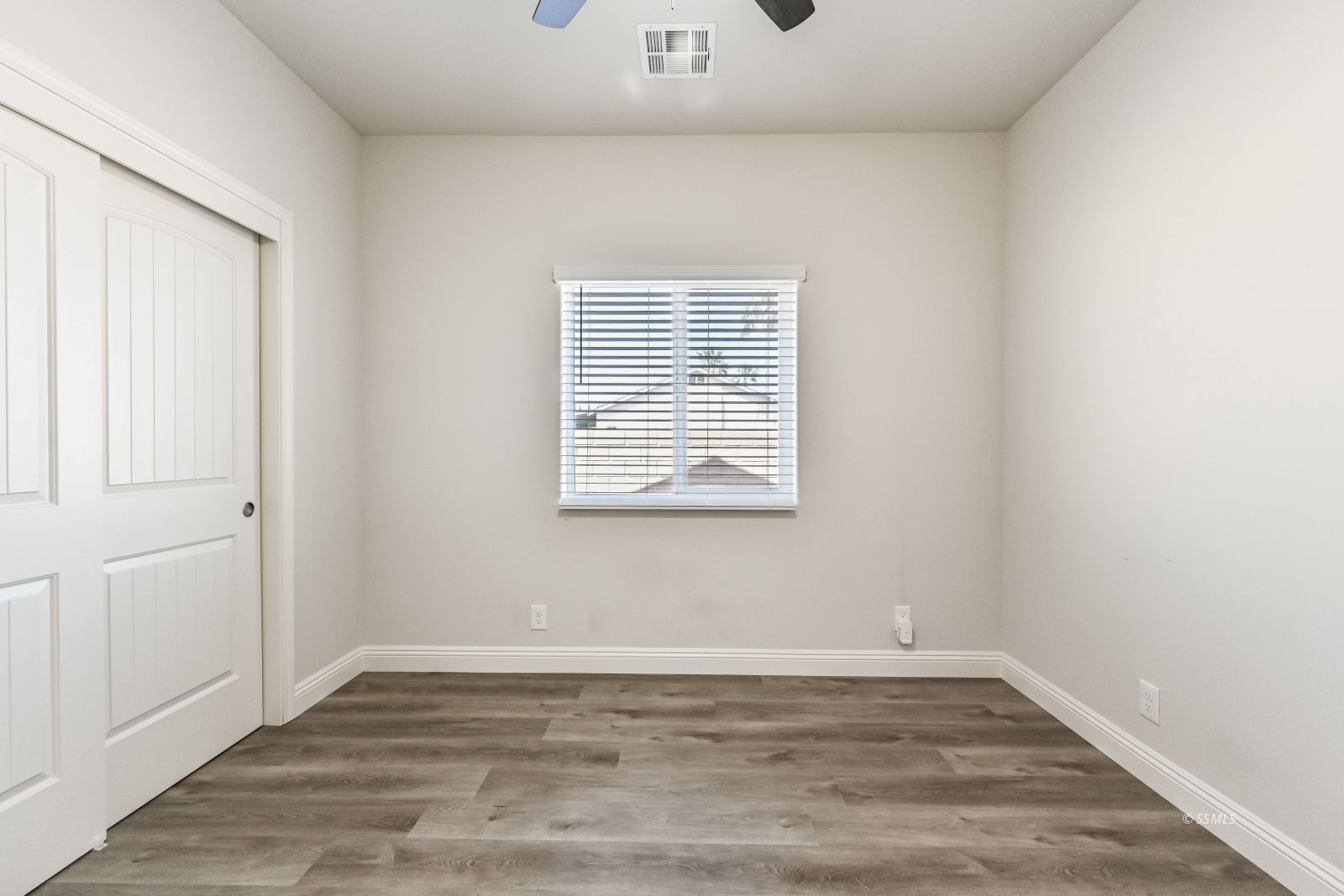 1031 West Church Avenue Ridgecrest, CA 93555 - Photo 37 of 49 an empty room with wooden floor and windows