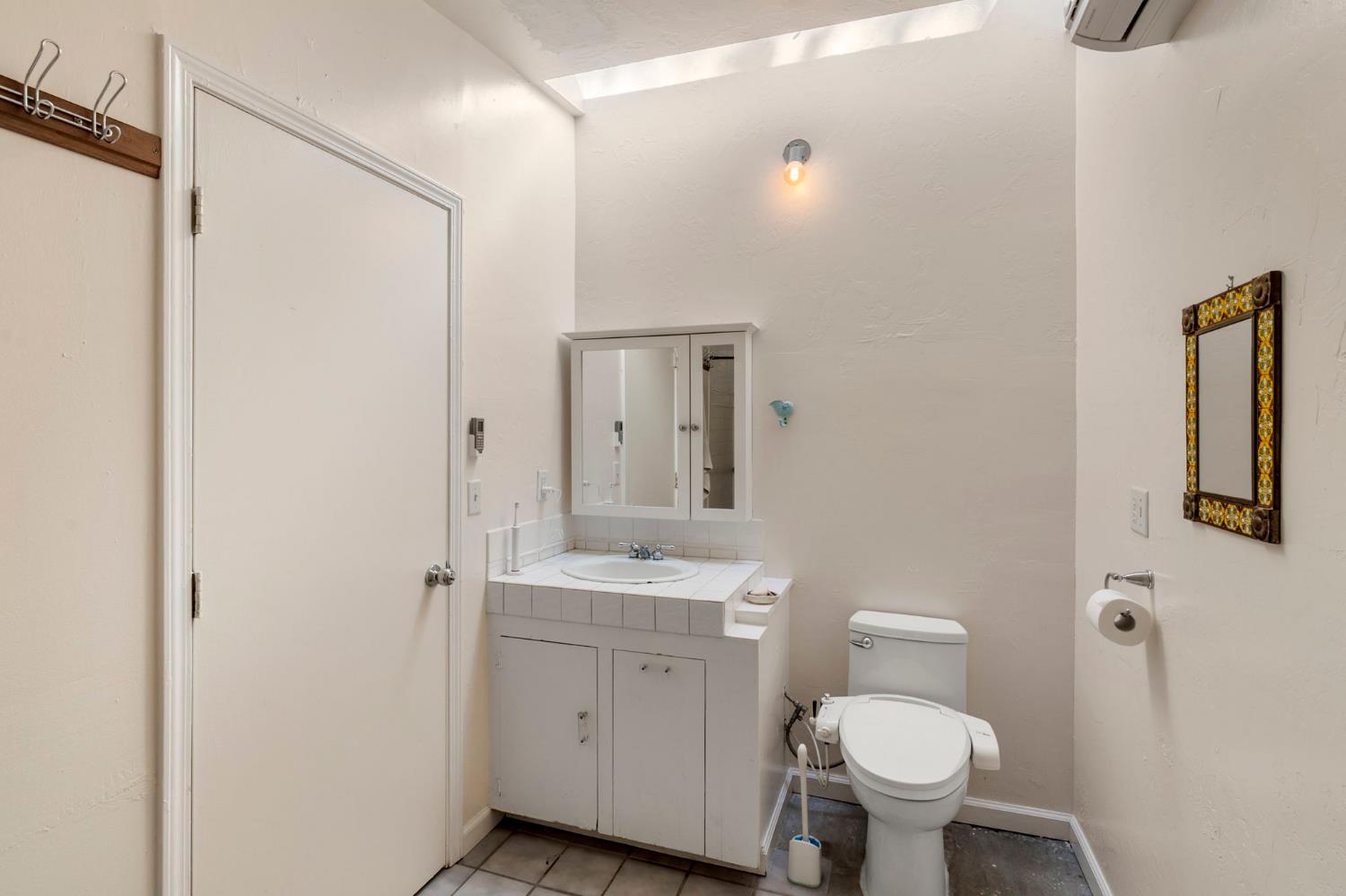 7123 Swiss Ranch Road Mountain Ranch, CA 95246 - Photo 33 of 66 a bathroom with a granite countertop toilet a sink and a mirror