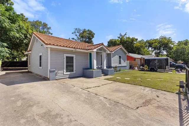 a front view of a house with a garden and yard