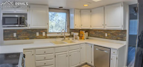 a kitchen with white cabinets and a sink