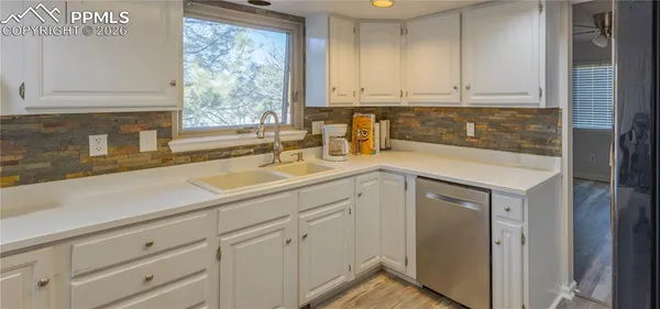 a kitchen with stainless steel appliances granite countertop white cabinets a sink and dishwasher