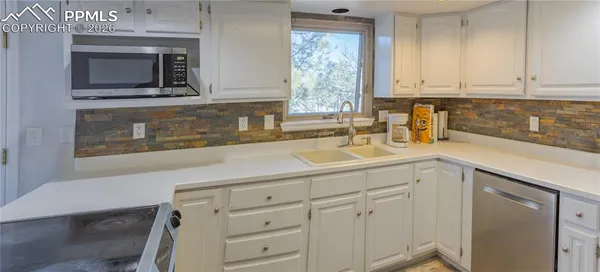 a large kitchen with stainless steel appliances a refrigerator and a stove top oven