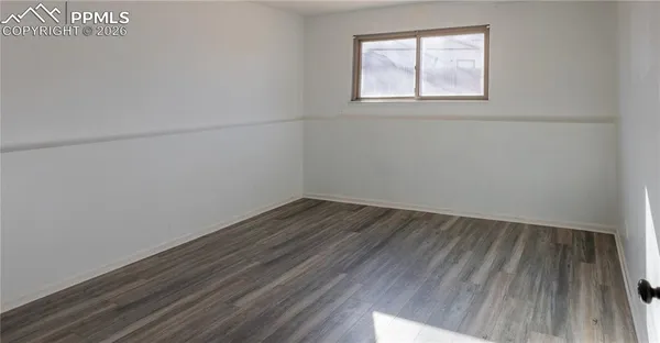 a view of a hallway with wooden floor and closet