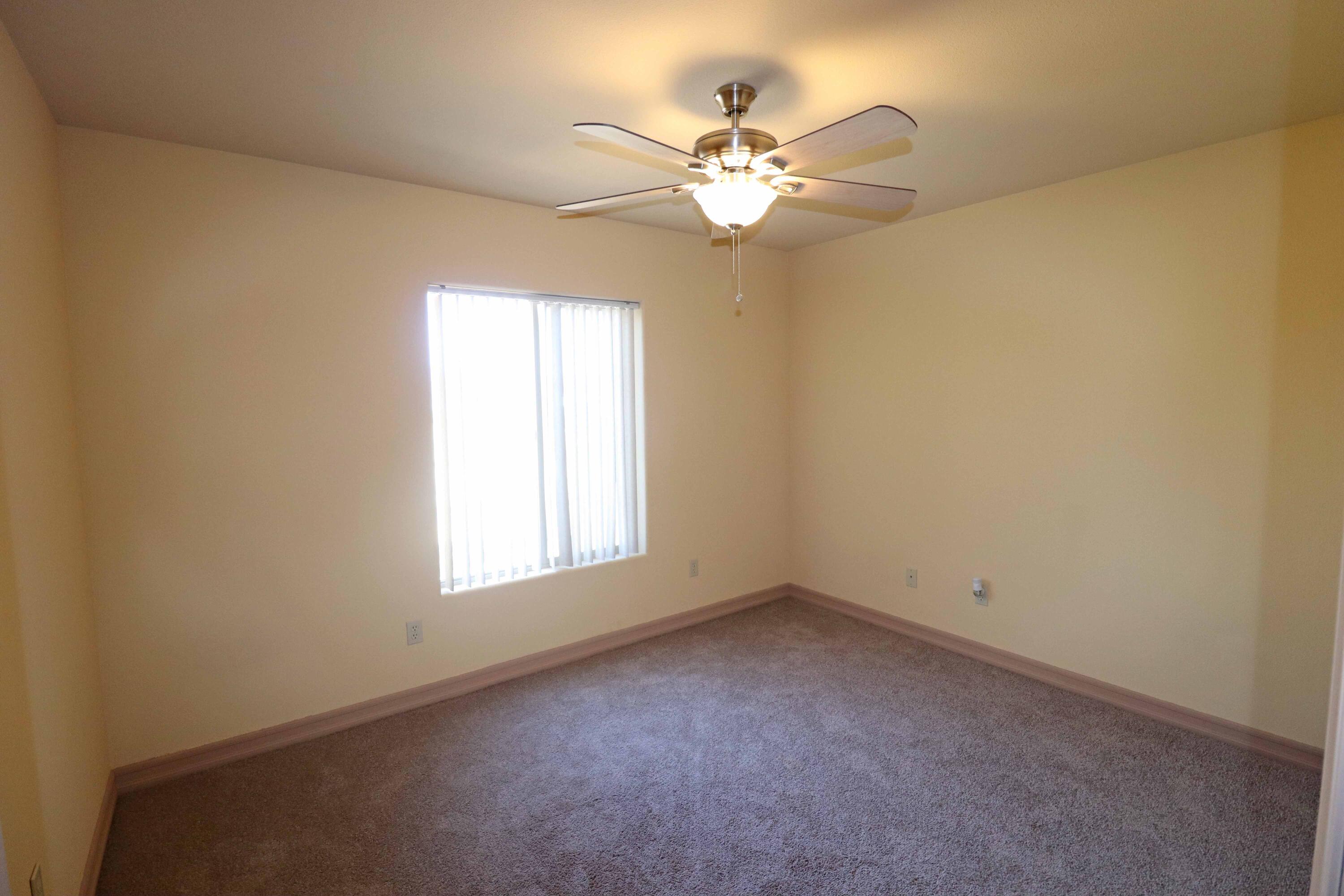 7201 Demesne Road Joshua Tree, CA 92252 - Photo 14 of 27 an empty room with a chandelier fan and windows