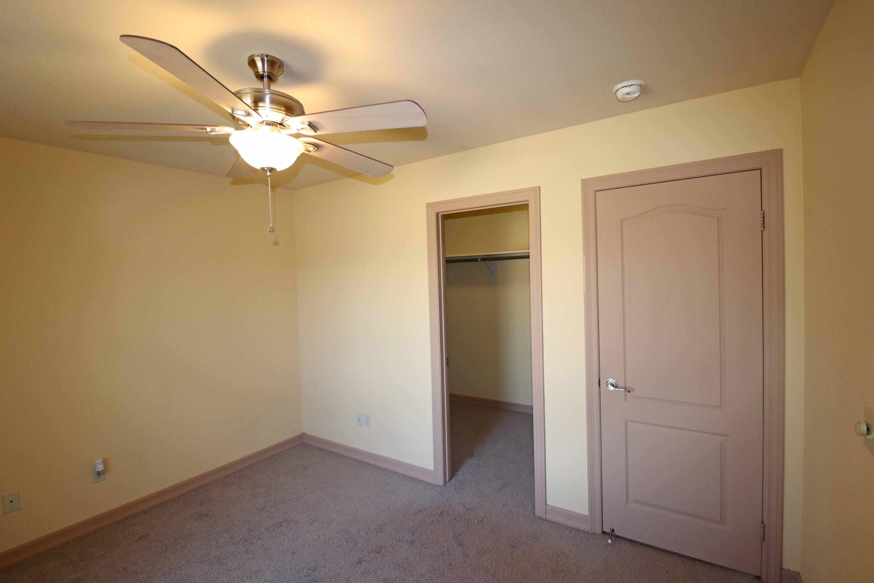 7201 Demesne Road Joshua Tree, CA 92252 - Photo 15 of 27 an empty room with a chandelier fan and a closet