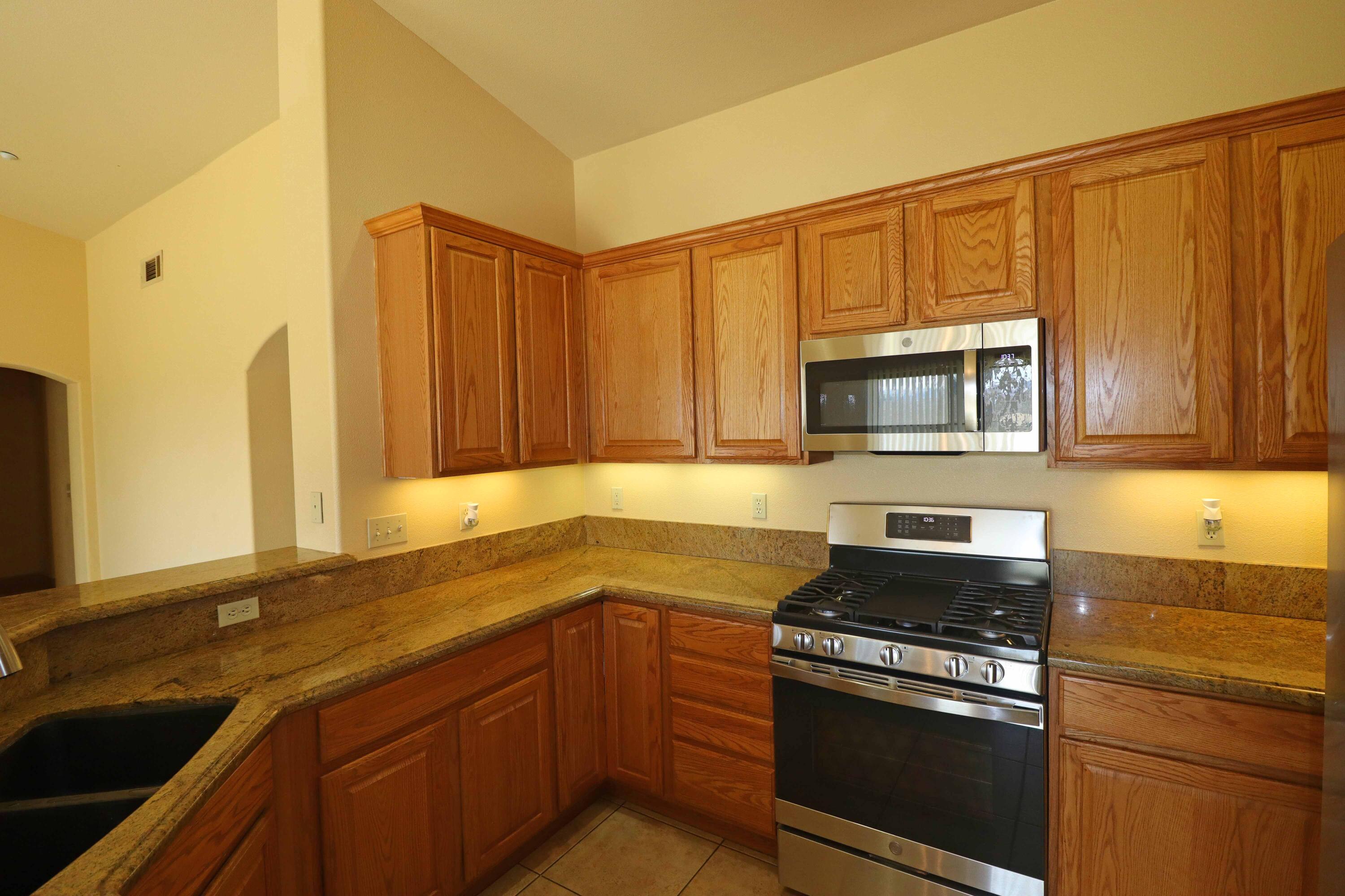 7201 Demesne Road Joshua Tree, CA 92252 - Photo 7 of 27 a kitchen with stainless steel appliances granite countertop a sink stove and microwave