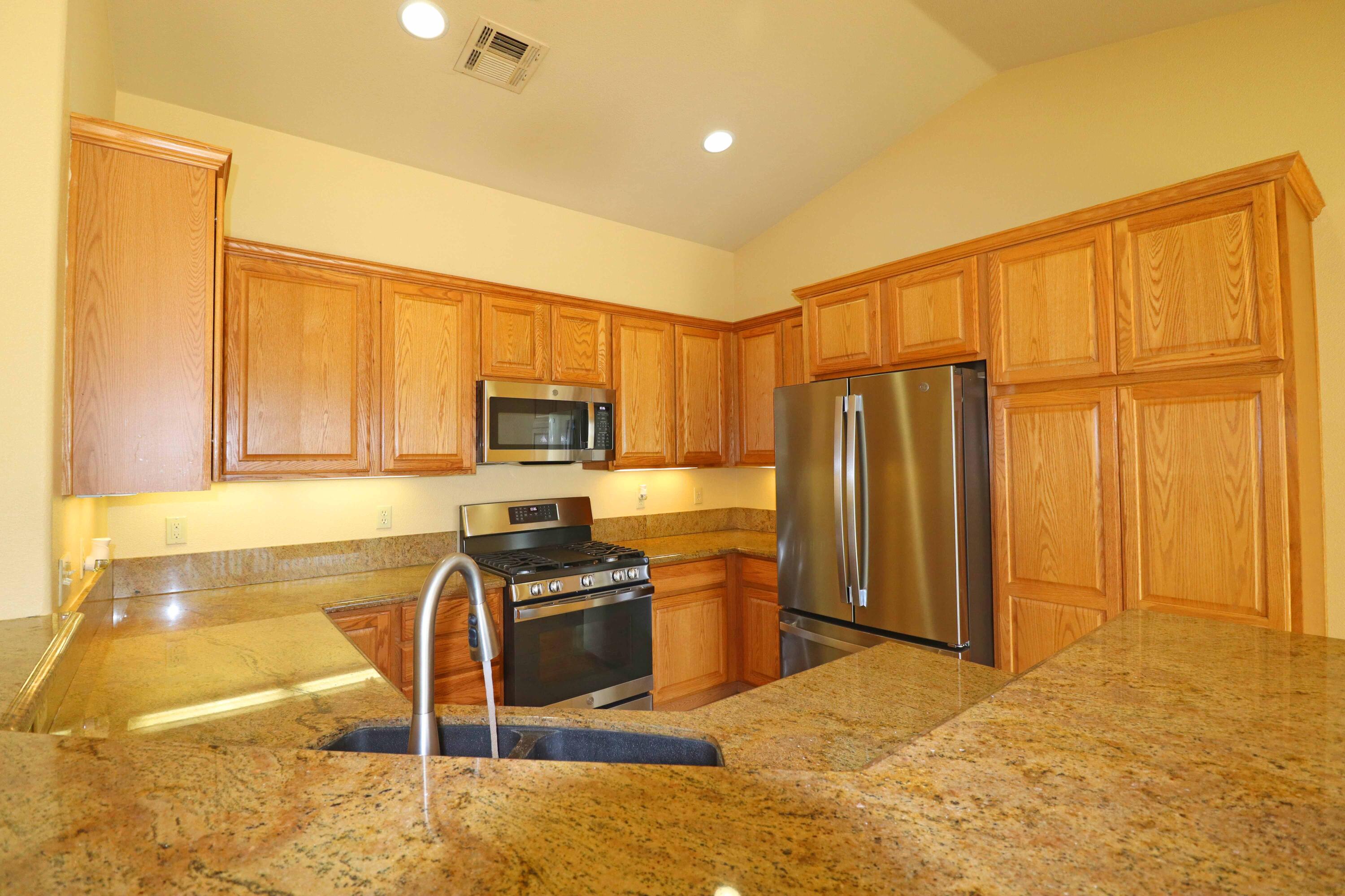 7201 Demesne Road Joshua Tree, CA 92252 - Photo 9 of 27 a kitchen with stainless steel appliances granite countertop a refrigerator stove and sink