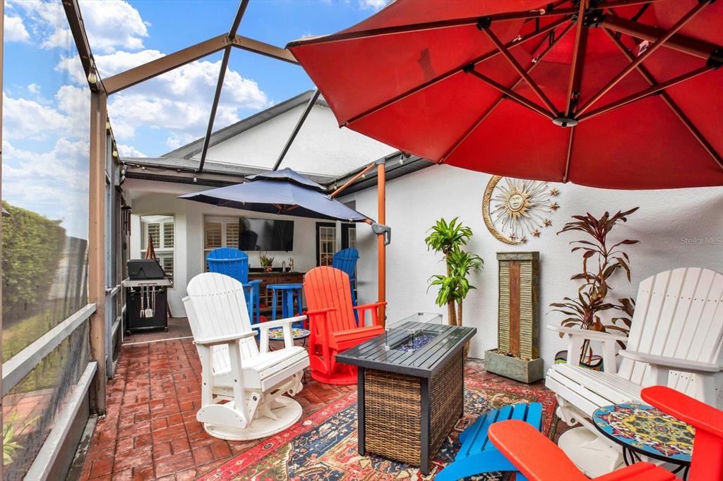 2021 Meadow Rue Court Trinity, FL 34655 - Photo 24 of 41 a patio with tables and chairs and a umbrella
