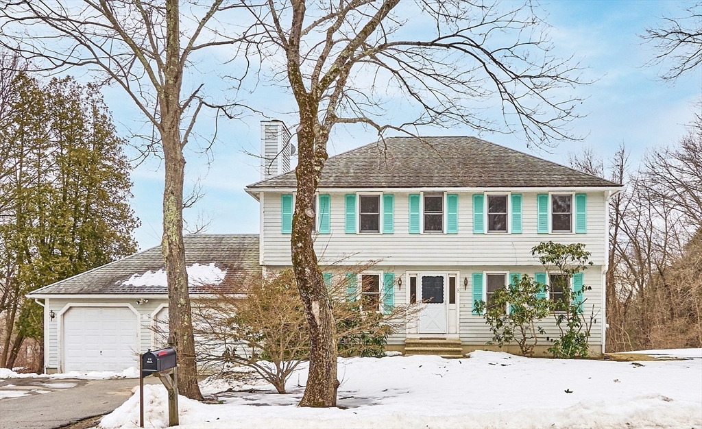 a front view of a house with a yard covered in snow