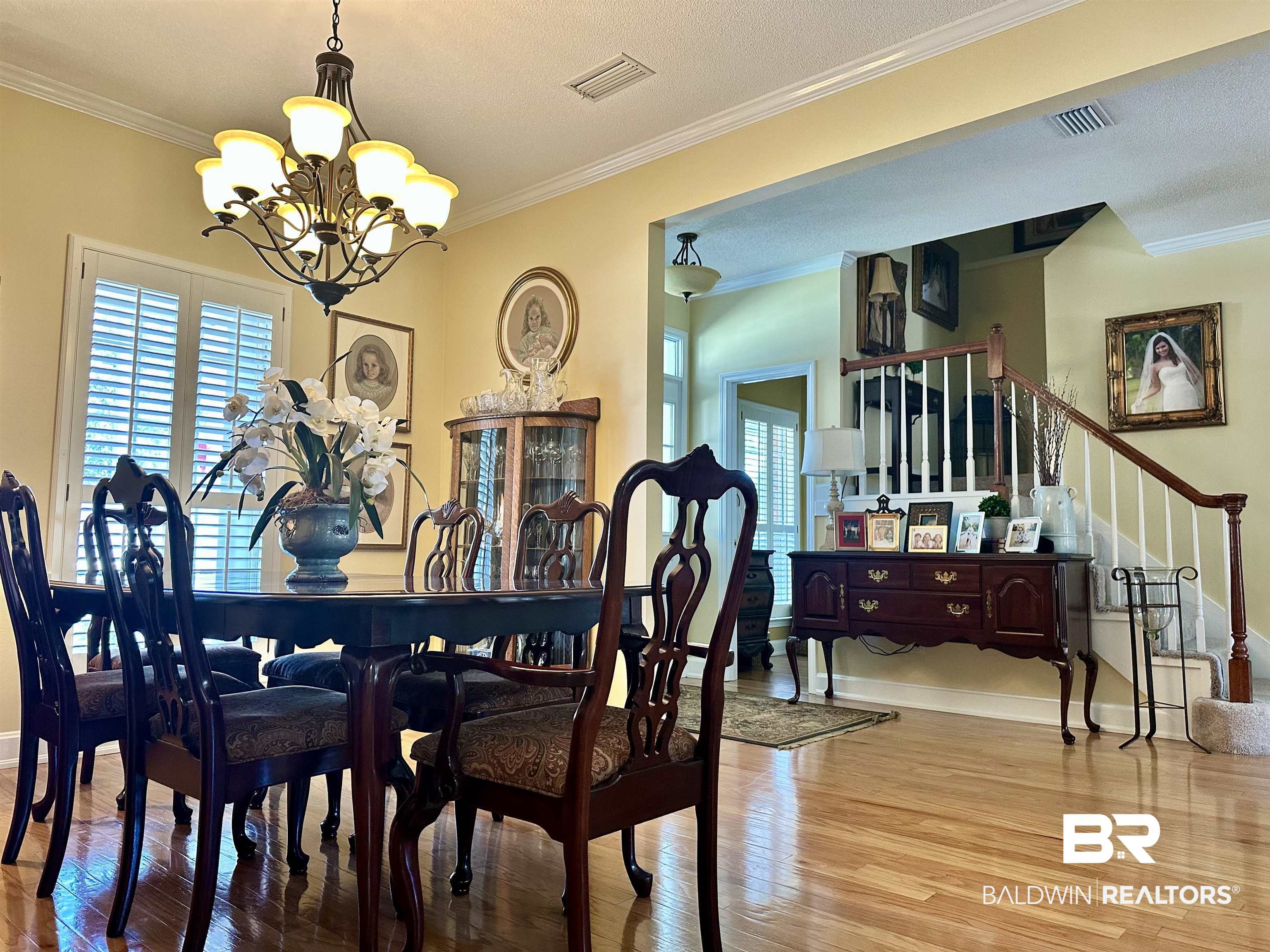 148 Brooks Boulevard Brewton, AL 36426 - Photo 9 of 45 Dining space featuring stairway, wood finished floors, visible vents, ornamental molding, and a notable chandelier