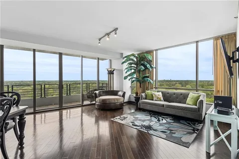 a living room with furniture and a large window with balcony view