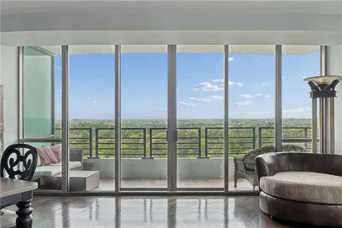 a living room with furniture and a floor to ceiling window