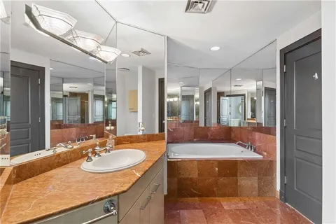 a bathroom with a sink a tub and a mirror