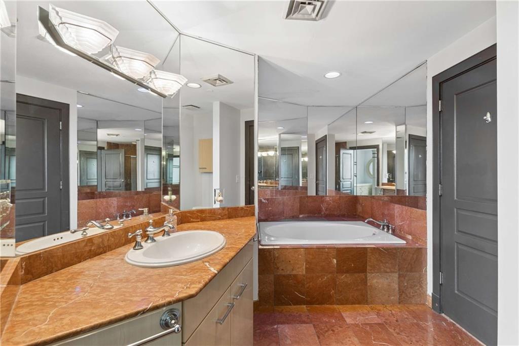 700 Park Regency Place Northeast, Unit 2002 Atlanta, GA 30326 - Photo 21 of 37 a bathroom with a sink a tub and a mirror