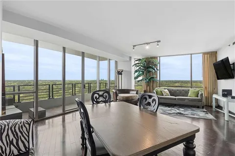 a living room with furniture tv and large windows