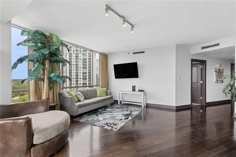 a living room with furniture wooden floor and a flat screen tv