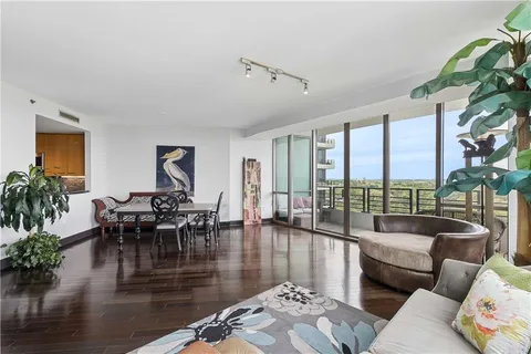 a living room with furniture floor to ceiling window and wooden floor