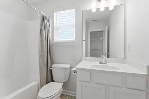 a bathroom with a sink toilet vanity and tub