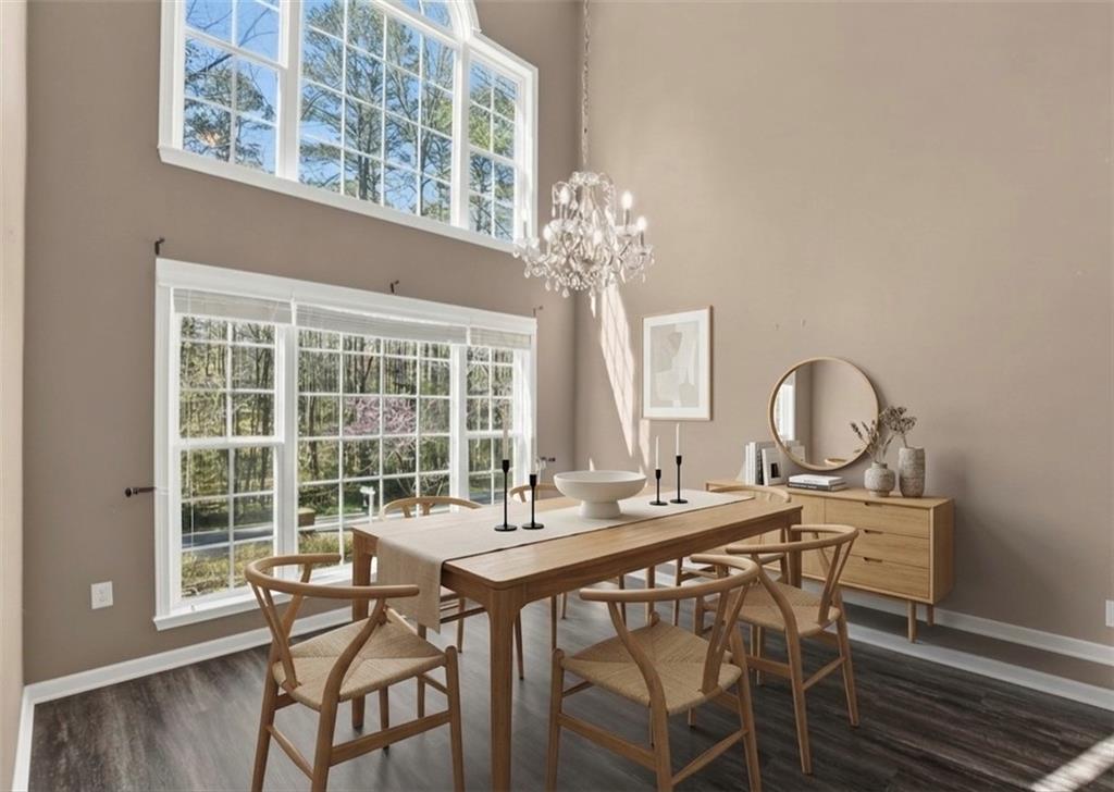 5976 Bowers Road Stone Mountain, GA 30087 - Photo 3 of 31 a dining room with wooden floor a chandelier a wooden table and chairs