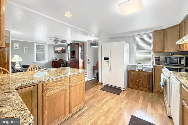 a kitchen with stainless steel appliances granite countertop a stove refrigerator and cabinets