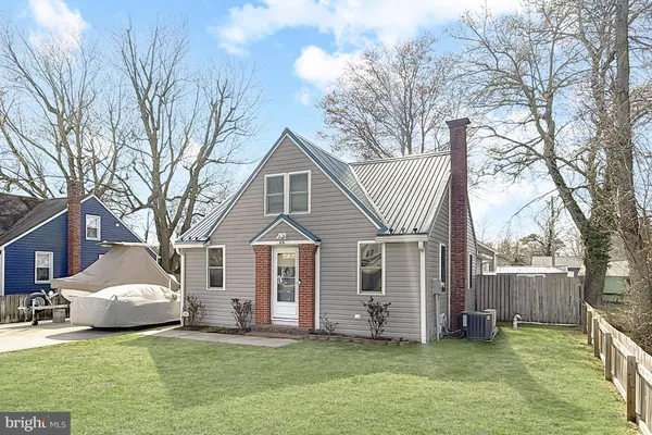 a white house that has a tree in front of a house