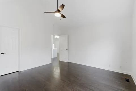 a view of empty room with wooden floor
