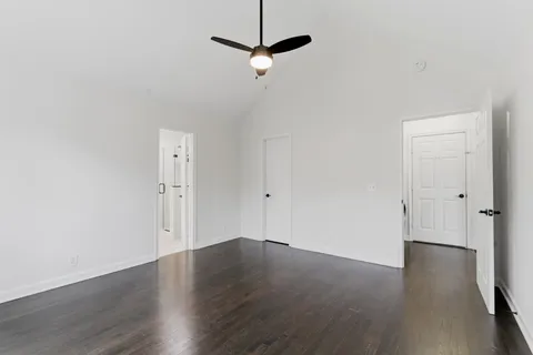 a view of a room with wooden floor and a ceiling fan