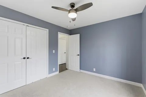 a view of an empty room and chandelier fan