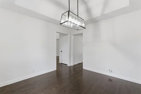 a view of a room with wooden floor and a chandelier