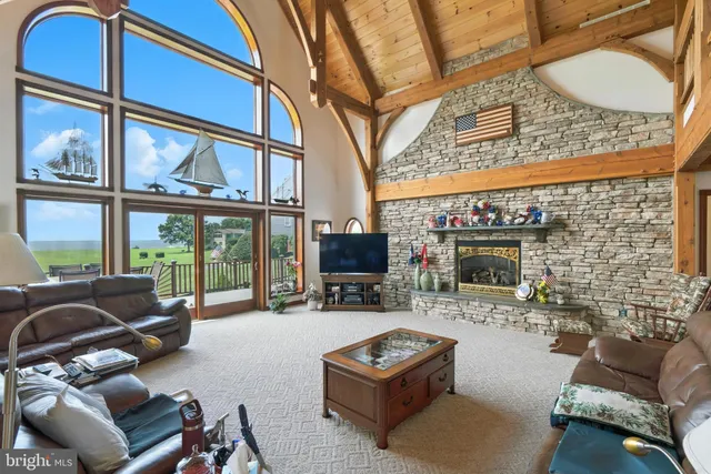 a living room with furniture a flat screen tv and floor to ceiling window