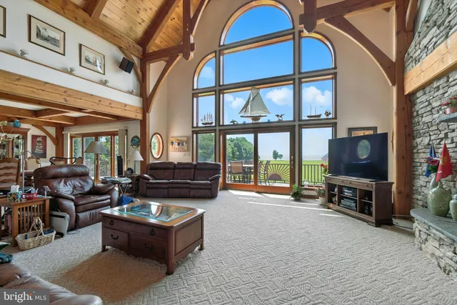 a kitchen with stainless steel appliances granite countertop a stove top oven a sink a dining table and chairs with wooden floor