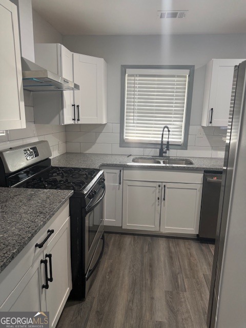 2899 Gresham Rd S East Atlanta, GA 30316 - Photo 3 of 17 a kitchen with a sink stove cabinets and wooden floor