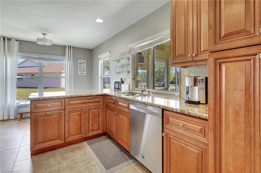 112 Versailles Circle Naples, FL 34112 - Photo 13 of 50 a kitchen with stainless steel appliances granite countertop a sink and cabinets