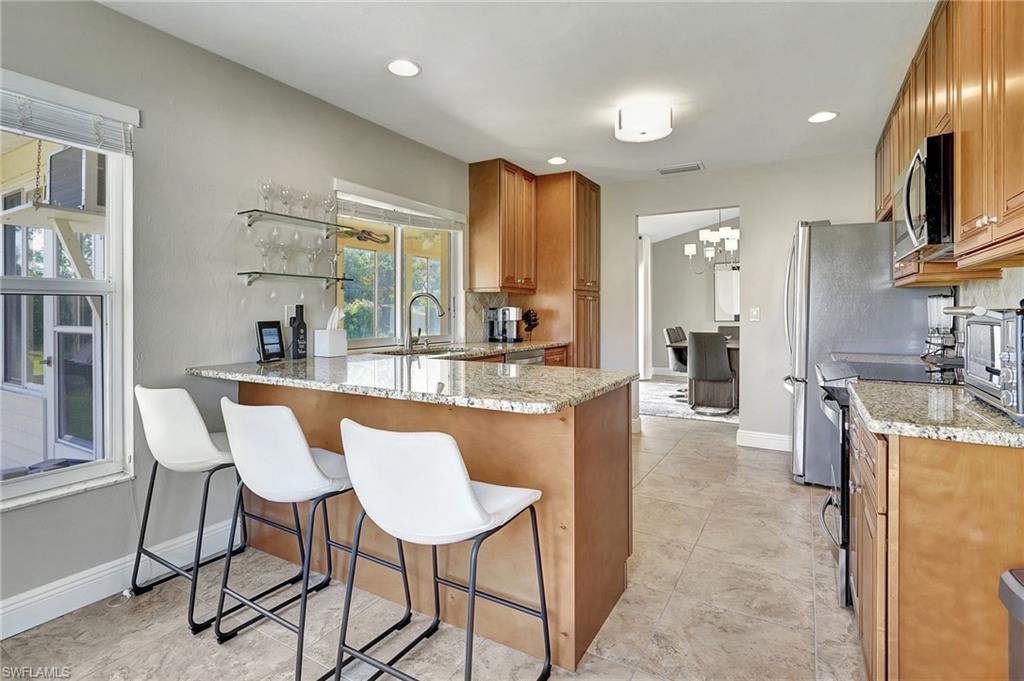 112 Versailles Circle Naples, FL 34112 - Photo 15 of 50 a dining hall with stainless steel appliances granite countertop a kitchen view and living room