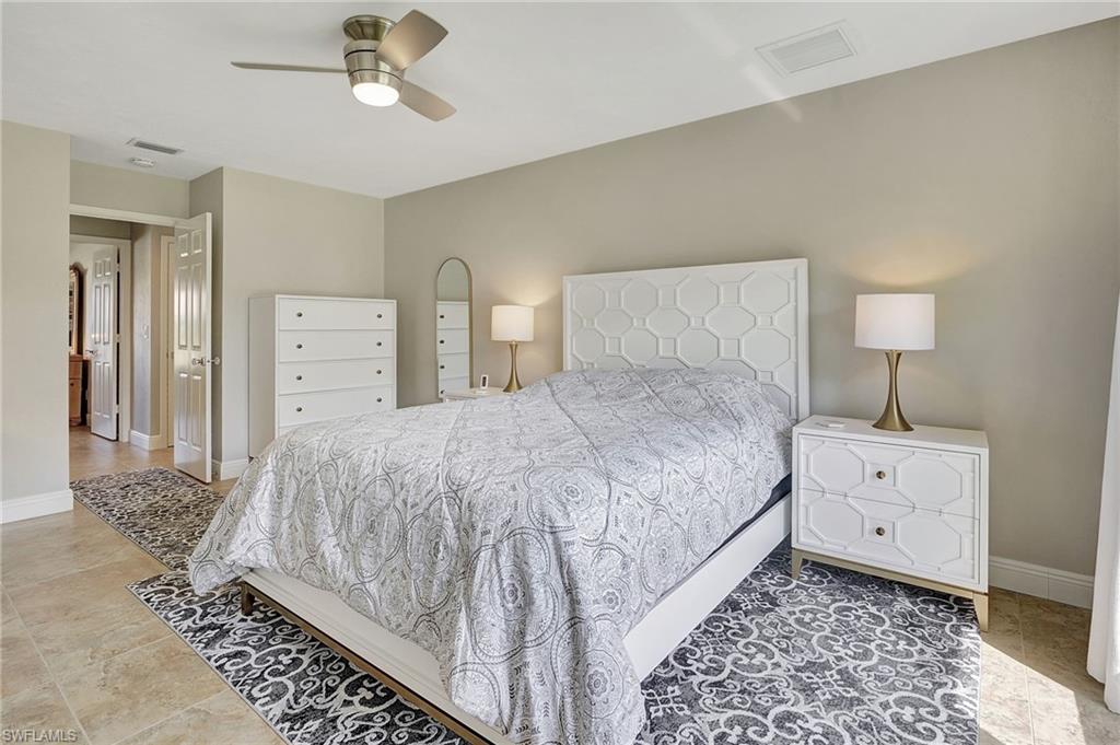 112 Versailles Circle Naples, FL 34112 - Photo 19 of 50 a bedroom with a bed and a chandelier