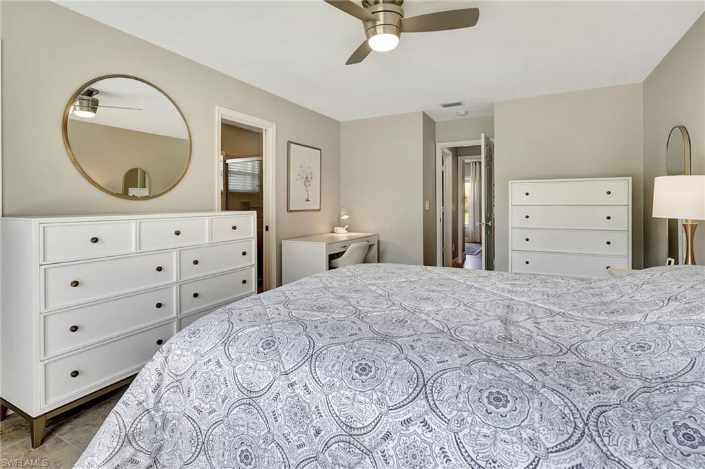 112 Versailles Circle Naples, FL 34112 - Photo 20 of 50 a bedroom with a large bed and a dresser