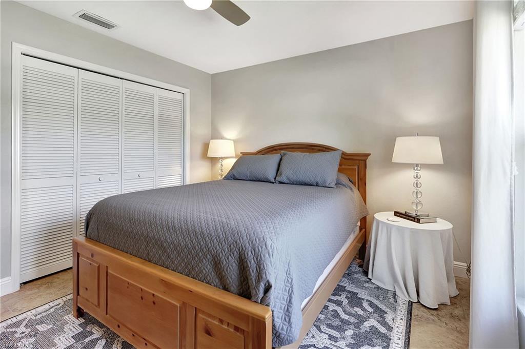 112 Versailles Circle Naples, FL 34112 - Photo 23 of 50 a bedroom with a bed and lamp
