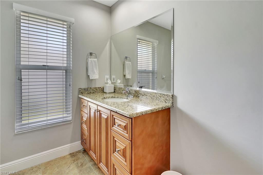 112 Versailles Circle Naples, FL 34112 - Photo 25 of 50 a bathroom with a sink and a mirror
